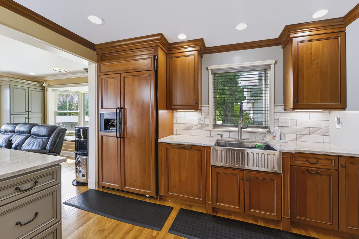 Formal dining room with warm hardwood floors and sunny garden window views