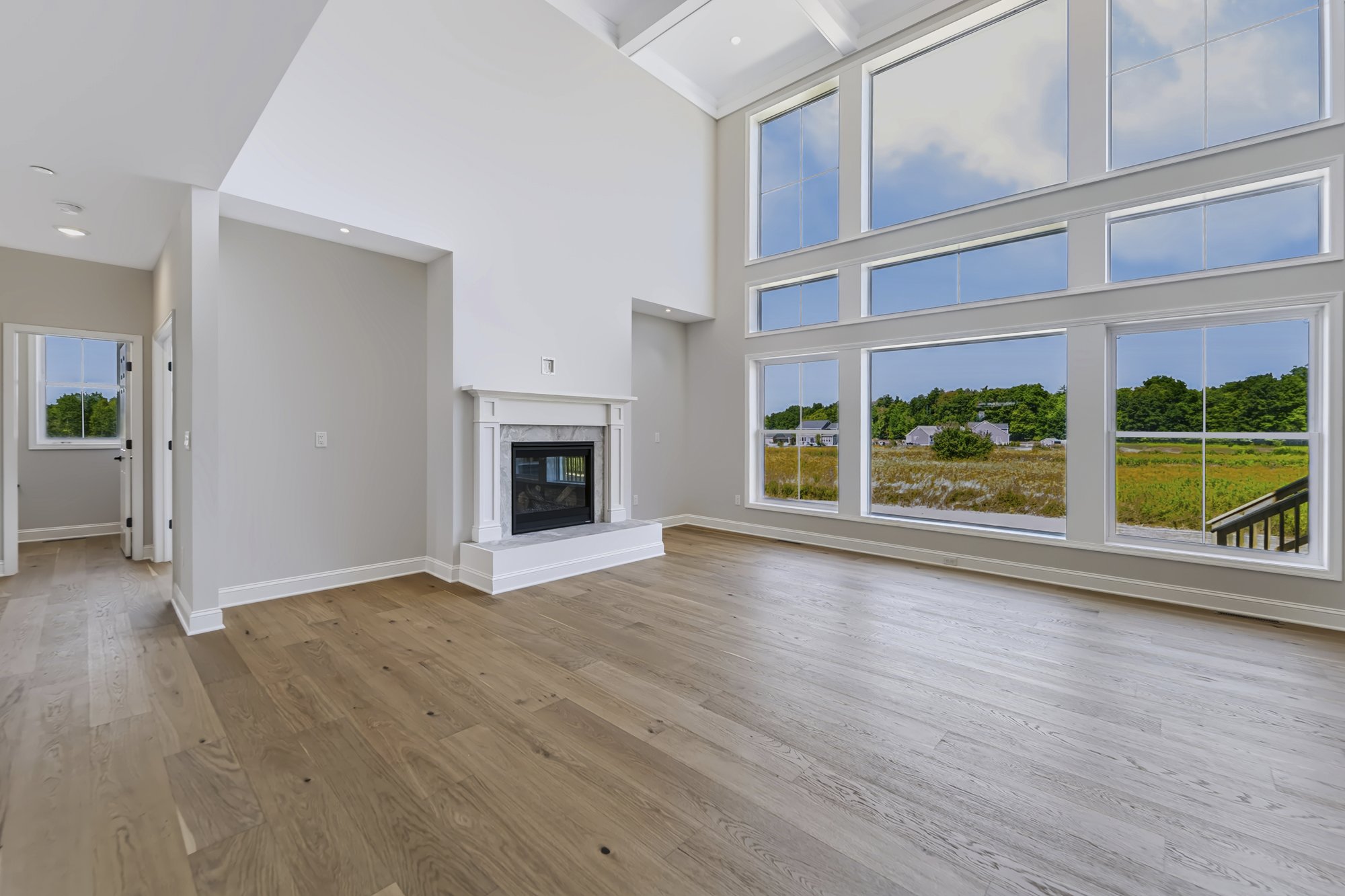Vaulted great room with fireplace and wall of windows — new construction real estate photography, Capital Region NY